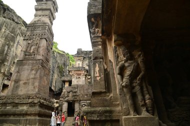 AURANGABUD, Hindistan - 25 Ağustos 2025: Kimliği belirsiz bir turist Ellora Mağaraları 'na seyahat ediyor. Antik Hindu Kaya Tapınağı. Kayadan oyulmuş Eski Hindu Tapınağı (Kailas Tapınağı). 16 numaralı mağara, Ellora Mağaraları, Aurangabad, Hindistan yakınlarında. MS 8. Yüzyıl.
