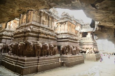 AURANGABUD, Hindistan - 25 Ağustos 2025: Kimliği belirsiz bir turist Ellora Mağaraları 'na seyahat ediyor. Antik Hindu Kaya Tapınağı. Kayadan oyulmuş Eski Hindu Tapınağı (Kailas Tapınağı). 16 numaralı mağara, Ellora Mağaraları, Aurangabad, Hindistan yakınlarında. MS 8. Yüzyıl.