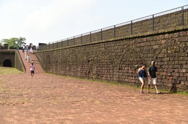 GOA, INDIA - 21 Ağustos 2025: Aguada Kalesi 'ni ziyaret eden kimliği belirsiz bir turist, Hindistan' ın Goa kentindeki Sinquerim Sahili 'nde bulunan bir deniz feneriyle birlikte 1612 yılında inşa edilmiştir. Kale Goa 'da büyük bir turizm merkezi..