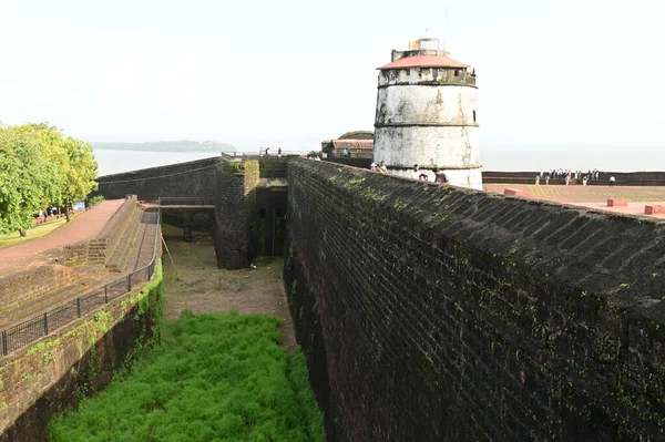 GOA, INDIA - 21 Ağustos 2025: Aguada Kalesi 'ni ziyaret eden kimliği belirsiz bir turist, Hindistan' ın Goa kentindeki Sinquerim Sahili 'nde bulunan bir deniz feneriyle birlikte 1612 yılında inşa edilmiştir. Kale Goa 'da büyük bir turizm merkezi..
