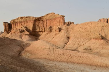 Çin 'in Xinjiang kentindeki Kizil Kızıl Taş Ormanı Bölgesi milyonlarca yıl boyunca rüzgar ve kumla oyulmuş garip şekilli kızıl kaya ormanlarıdır. Kayalar, bileşimlerindeki demir içeriği nedeniyle kırmızı renktedir..