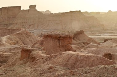 Çin 'in Xinjiang kentindeki Kizil Kızıl Taş Ormanı Bölgesi milyonlarca yıl boyunca rüzgar ve kumla oyulmuş garip şekilli kızıl kaya ormanlarıdır. Kayalar, bileşimlerindeki demir içeriği nedeniyle kırmızı renktedir..