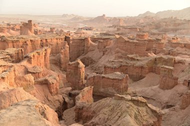 Çin 'in Xinjiang kentindeki Kizil Kızıl Taş Ormanı Bölgesi milyonlarca yıl boyunca rüzgar ve kumla oyulmuş garip şekilli kızıl kaya ormanlarıdır. Kayalar, bileşimlerindeki demir içeriği nedeniyle kırmızı renktedir..