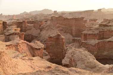 Çin 'in Xinjiang kentindeki Kizil Kızıl Taş Ormanı Bölgesi milyonlarca yıl boyunca rüzgar ve kumla oyulmuş garip şekilli kızıl kaya ormanlarıdır. Kayalar, bileşimlerindeki demir içeriği nedeniyle kırmızı renktedir..