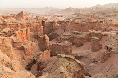 Çin 'in Xinjiang kentindeki Kizil Kızıl Taş Ormanı Bölgesi milyonlarca yıl boyunca rüzgar ve kumla oyulmuş garip şekilli kızıl kaya ormanlarıdır. Kayalar, bileşimlerindeki demir içeriği nedeniyle kırmızı renktedir..