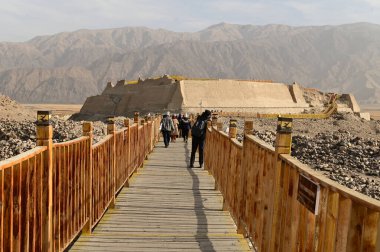 Xinjiang, Çin 20 Ekim 2025: Kimliği belirsiz bir turist taştan bir şehir olan Tashgurgan 'a doğru yürüyor. Konum: Tashgur Şehri, Tacikistan Özerk Bölgesi.