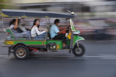 BANGKOK, THAILAND - HAZİRAN 1, 2026: Bangkok 'un başkenti Saphan Phut Köprüsü bölgesinde 3 tekerlekli bir araçta çalışan kimliği belirsiz bir sürücü ve bir yolcu..