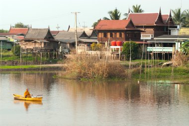 Buddhist monks are given food offering from people by boat.