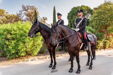 Syracuse Sicilya İtalya - 22 Temmuz 2021: Neapolis arkeoloji parkında at sırtında iki gururlu jandarma