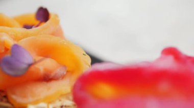 bright, juicy bruschetta from red fish and greens. delicious red fish, beautifully laid on fresh bread and seasoned with spices. haute cuisine. French cuisine. close-up. bright colours. juicy shots of french cuisine