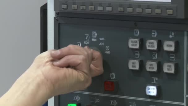 Close up of worker's hands operating the computer controls on a CNC lathe. Tilt up to screen. — Stock Video