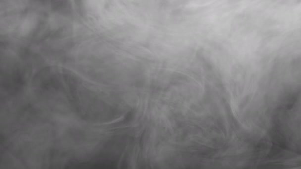 Swirling smoke rises up and fills the screen.  Recorded against a black background and intended as a stand alone shot or for compositing with graphics or using a blending mode.  Looping clip — Stock Video