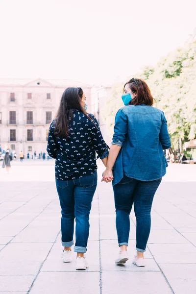 Pareja Mujeres Con Una Máscara Facial Caminando Mano —  Fotos de Stock