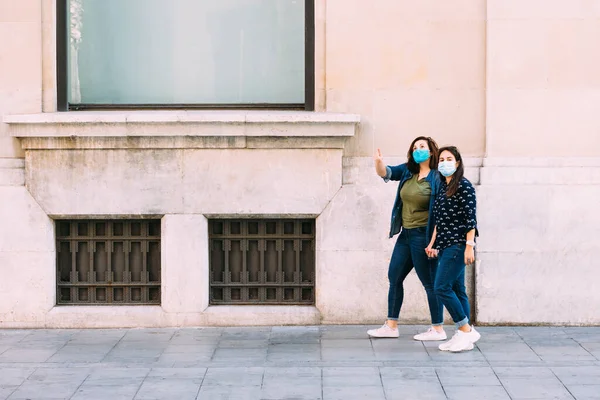 Pareja Mujeres Con Una Máscara Facial Caminando Mano —  Fotos de Stock