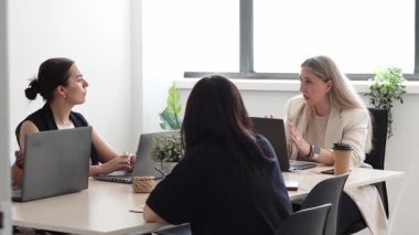 Bir grup kadın ofiste iş toplantısındayken bilgisayara bakıyorlar..