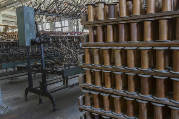 Thread factory floor with wooden bobbins