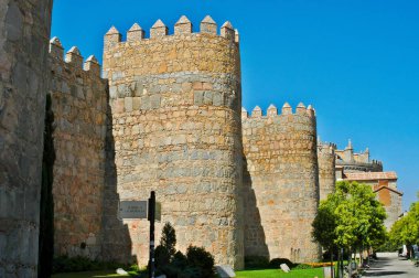 Avila 'nın eski ortaçağ duvarları ve güçlendirilmiş kuleleri açık bir yaz gökyüzü altında tarih ve savunmanın bir vasiyetini sunar.