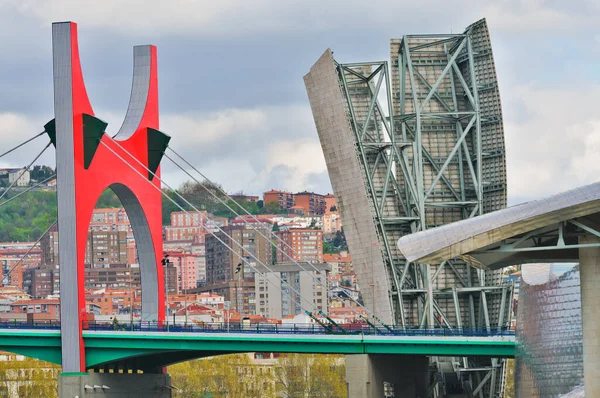 Guggenheim Müzesi 'nin modern mimari eğrilerine bağlanan canlı kırmızı La Salve Köprüsü' nün yer aldığı Bilbao şehir manzarası