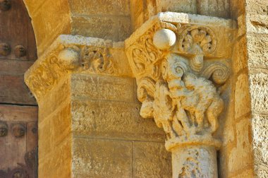 Antik taş sütun sermayesi, Roma 'ya ait bir kilise portalında ortaçağ figürleri ve biçimlendirilmiş yaprak desenlerini gösteriyor.