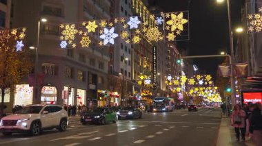 Madrid, İspanya, Noel, 12-14-2025: İspanya 'nın Madrid kentinde Noel süslemeleri ve gece yoğun trafiği bulunan festival caddesi
