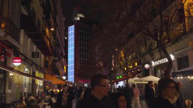 Madrid, İspanya, Noel, 12-14-2025: Avrupa 'nın canlı bir caddesindeki açık hava restoranları ve kafelerin önünden geçen kalabalık