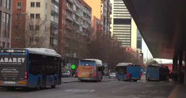 Madrid, İspanya, 01-20-2026: Yolun sol tarafında Kabare otobüsü olan işlek bir şehir caddesi. Yolda başka otobüsler ve arabalar var.