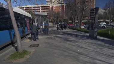 Madrid, İspanya, 02 23 2025, güneşli bir günde, bebek arabasıyla şehir otobüsüne binen bir adam.