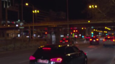 Gece şehir caddesinde araba sürüp, bokeh ışıkları yaratan odaksız arabalar.