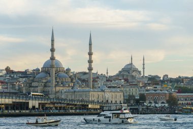 İstanbul 'un çok sayıda caminin ve teknelerin bulunduğu Skyline manzarası. Yürüyen insanların olduğu bir köprü içerir.