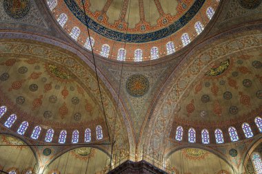 Görüntü, dini mimaride ayrıntılı zanaatkârlık sergilenen kemerler, süslü dekorasyonlar ve vitray pencereli karmaşık bir kubbe mimarisine sahip. İstanbul, Türkiye.