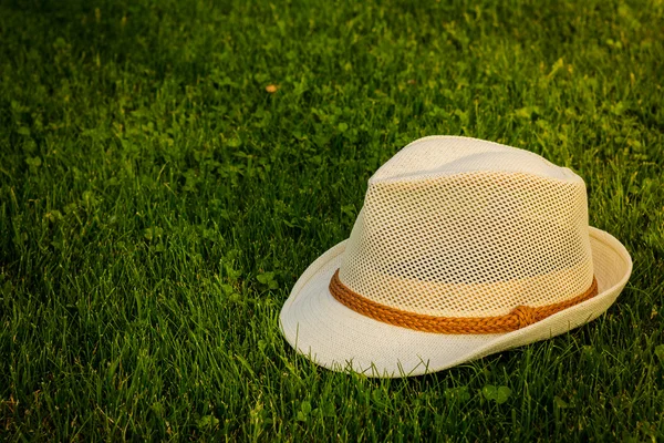 Chapéu branco na grama — Fotografia de Stock