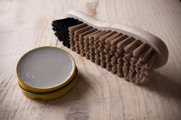 Contenedor de esmalte de zapatos y cepillo sobre fondo de madera —  Fotos de Stock