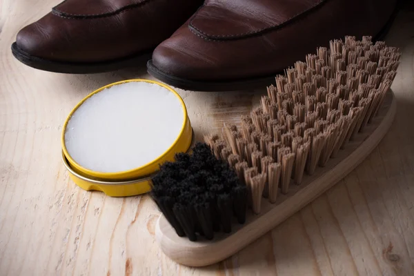 Φροντίδα παπουτσιών. Παπούτσι κερί και βούρτσες σε ξύλινη επιφάνεια. Παπούτσια Glacage — Φωτογραφία Αρχείου