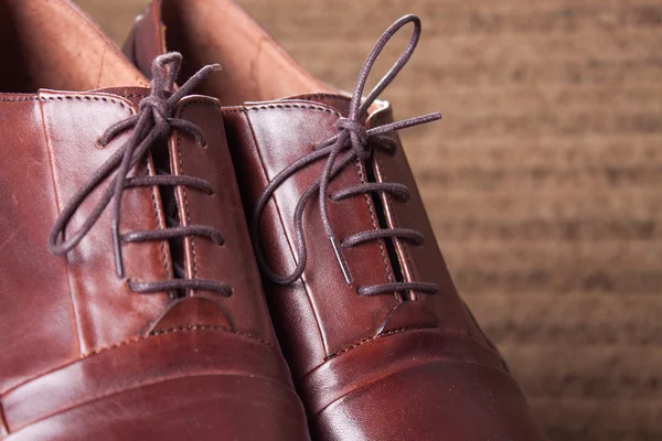 Handgemaakte bruin lederen schoenen gehouden op een houten vloer — Stockfoto