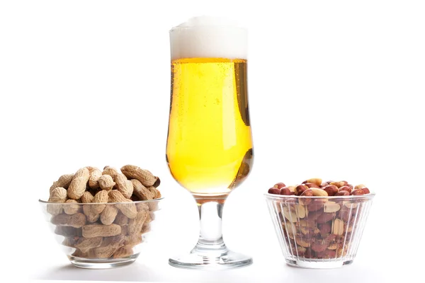 Pint of lager and peanuts on white background Royalty Free Stock Photos