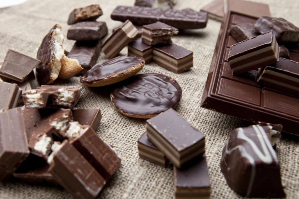 Barra de chocolate rota y especias en mesa de madera — Foto de Stock