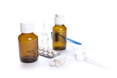 Beyaza izole edilmiş farklı ilaç şişeleri ve tabletler.