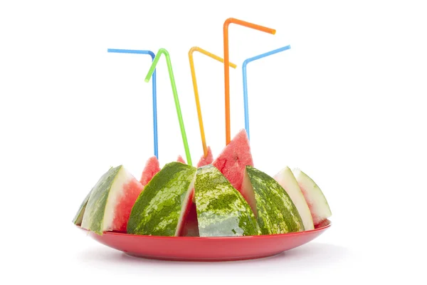 Reife Wassermelone in Stücke mit einem Tubulus auf dem Teller — Stockfoto