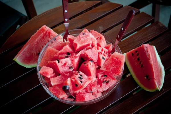 Watermelon picies in transparent bowl on wooden table — Stock Photo, Image