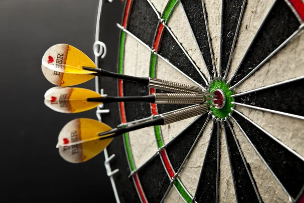 Drie Darten in bullseye van dartbord — Stockfoto