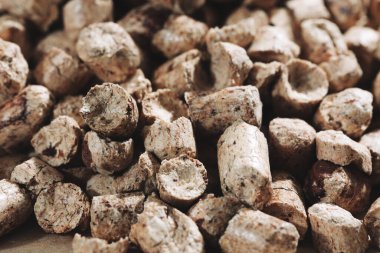 Katı yakıt kazanlarıyla endüstriyel kazan dairesini ısıtmak için bir demet ahşap topak. Biyokütle topaklarının yakın plan makro görüntüsü. Çevre dostu ve düşük maliyetli yakıt kavramı