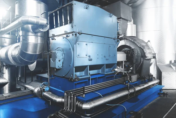 Rankine organic cycle turbine (ORC-turbine) installed in modern industrial boiler room, equiped for heating process. A part of  uncondensable extraction system with blue toning.