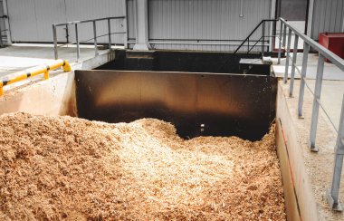 Katı yakıt endüstriyel kazan dairesinde odun parçaları depolamak için bir sığınak. Ahşap endüstrisinin atıklarıyla dolu beton bir tank.. 