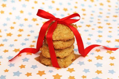 Kırmızı kurdeleli yulaflı kurabiyeler yıldızlı arka planda.