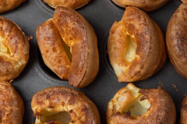 Yorkshire pudinglerinin fırın tepsisinin içinde otururken yakın çekim görüntüsü.