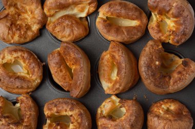 Yorkshire pudinglerinin fırın tepsisinin içinde oturduğu tepeden aşağı bir manzara.