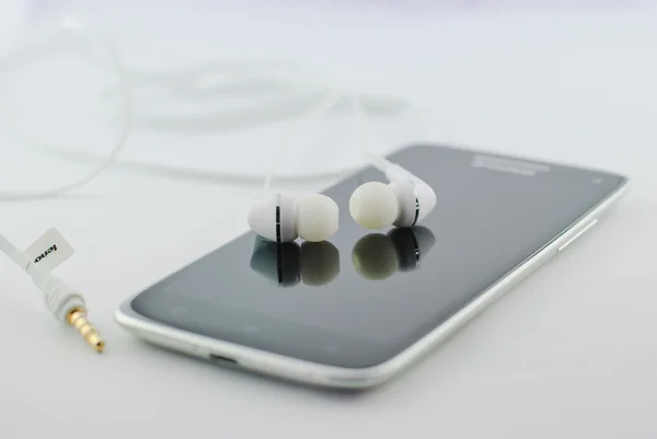 Auriculares pequeños con teléfono móvil — Foto de Stock