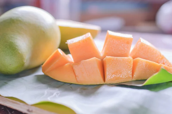 Reife Mango mit Scheiben auf Bananenblättern — Stockfoto