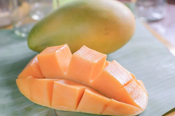 Reife Mango mit Scheiben auf Bananenblättern — Stockfoto