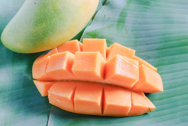 Reife Mango mit Scheiben auf Bananenblättern — Stockfoto